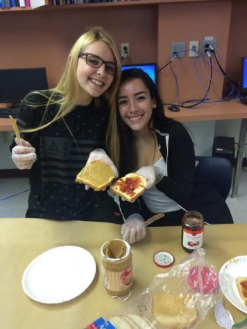 Sophomores Gabby Suarez and Kayla Webster divide the task of spreading  peanut butter and jelly.