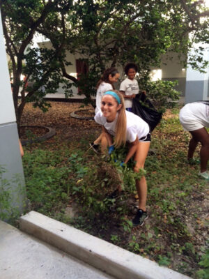 Community Clean-up. Along with her teammates from the women’s varsity soccer team, senior Emma Jacobs helps pull out weeds in a planted area of the MSD courtyard. Jacobs favorite form of community service is volunteering at local soccer camps, where she can help teach kids how to play soccer.