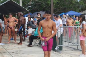 Sophomore Cody Chin takes off his cap and goggles after swimming the 50 meter freestyle.