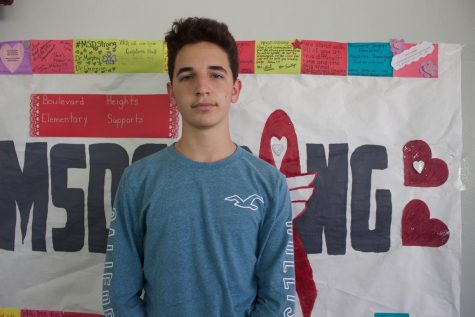 Freshman Jason Snytte poses next to an MSD Strong poster during his second week back to school. Photo by Anna Dittman