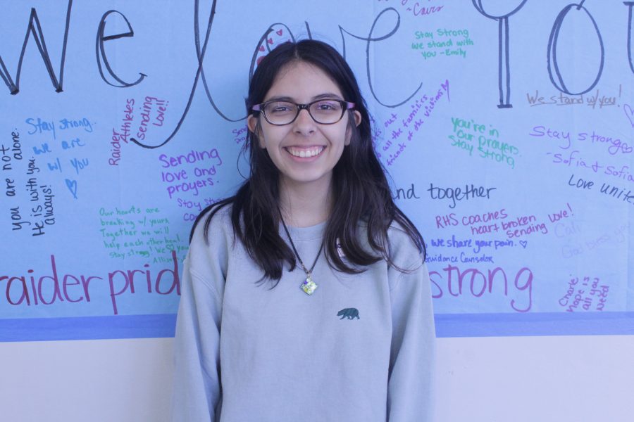 Junior Isabel Chequer smiles next to a banner donated to MSD. Photo by Anna Dittman