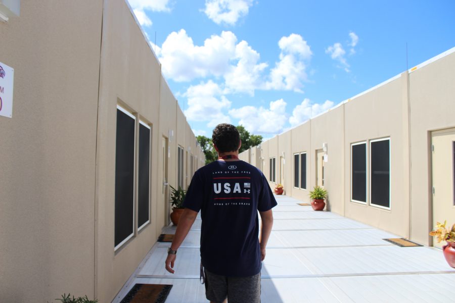 Taking a Stroll. Junior Harris Jaffe walks back to his 8th period debate class in Eagle Village. Photo by Rebecca Schneid