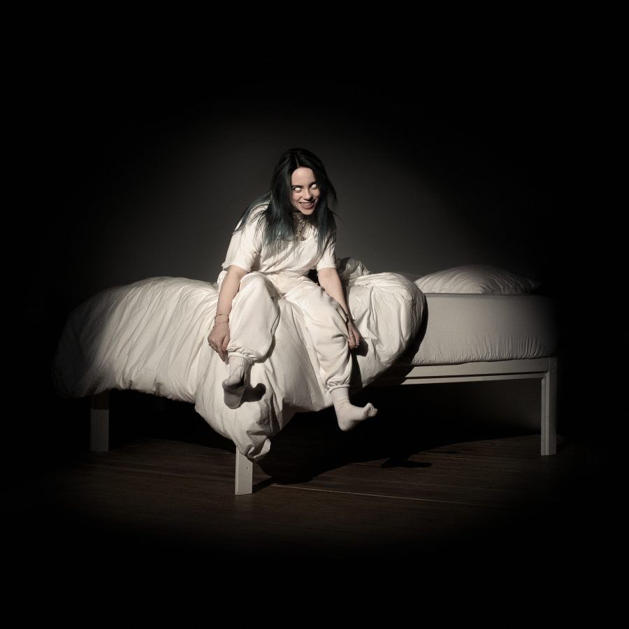 Billie Eilish's cover for her new album "WHEN WE ALL FALL ASLEEP WHERE DO WE GO?" featuring herself sitting on a bed, smiling and her eyes whited-out