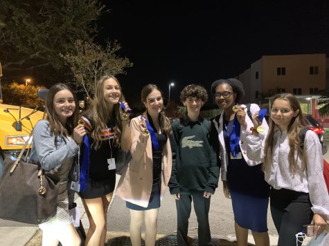 MSDs speech and debate students hold up medals earned from their last tournament of the first semester.