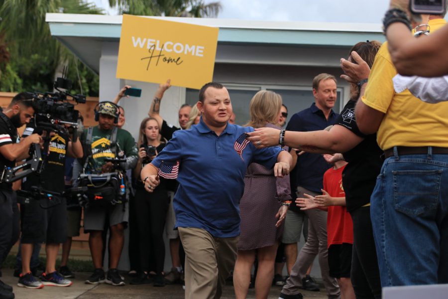 Corey Hixon runs excitedly to hug "Military Makeover" co-host Art Edmonds after his renovated house is revealed to him on Friday, Dec. 13. Photo by Darian Williams