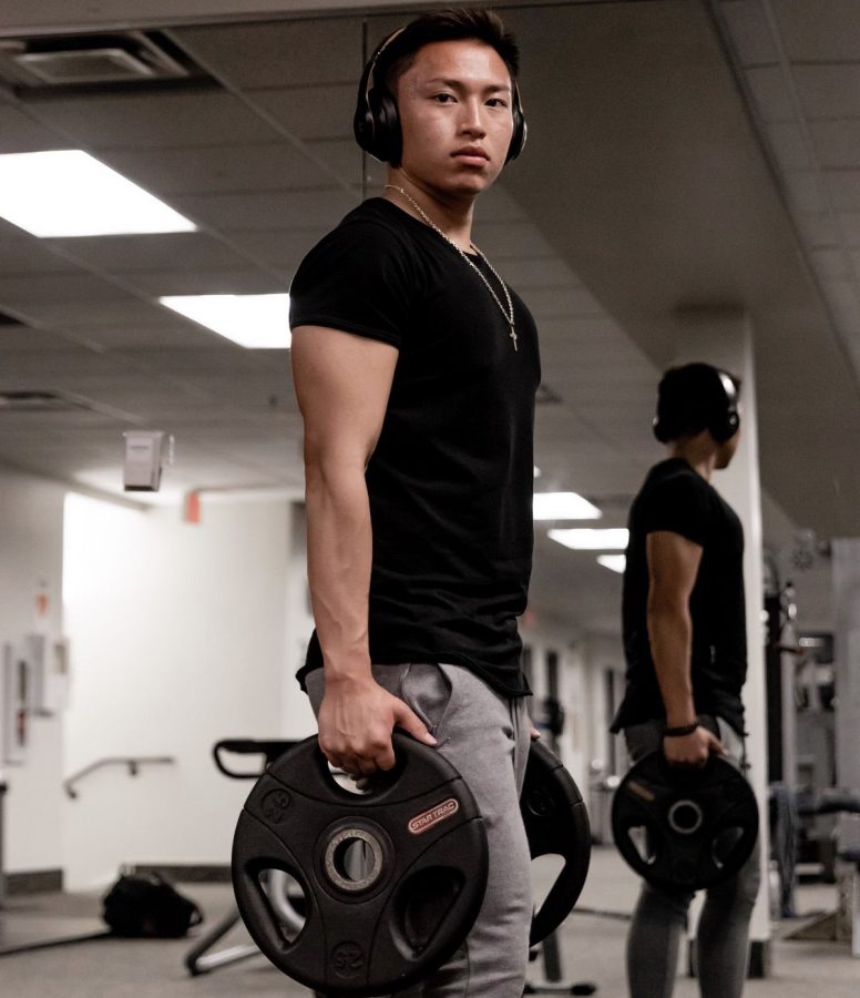 Stoneman Douglas alumni Brandon Chen locked into his workout, with headphones to play the songs he needs to keep himself focused. Photo by Darian Williams