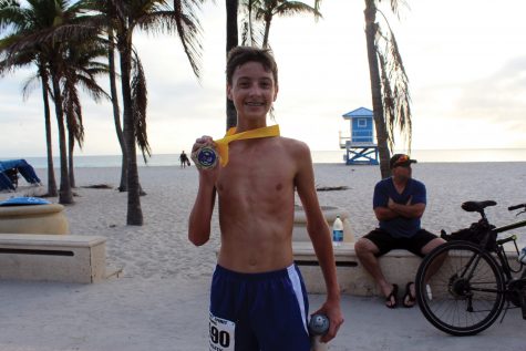 Olympic Heights High school freshman Jacob Weiner poses with his first place medal at the second annual Chris Hixon Memorial 5K Run/Walk. Weiner crossed the finish line first with a time of 20:17.4. Photo by Elama Ali