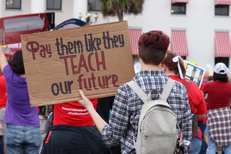 A protester holds up their homemade sign made out of cardboard at the Fund Our Future rally in Tallahassee, Florida on Monday, Jan.13.