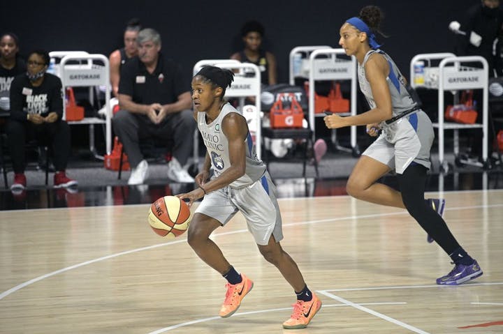 professional female basketball dribbles the basketball down the basketball court