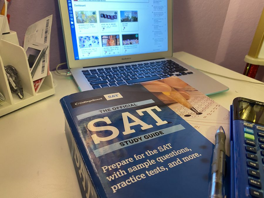 An+SAT+prep+book+is+resting+next+to+a+laptop+with+school+materials+open.+Photo+by+Ariella+Bishari