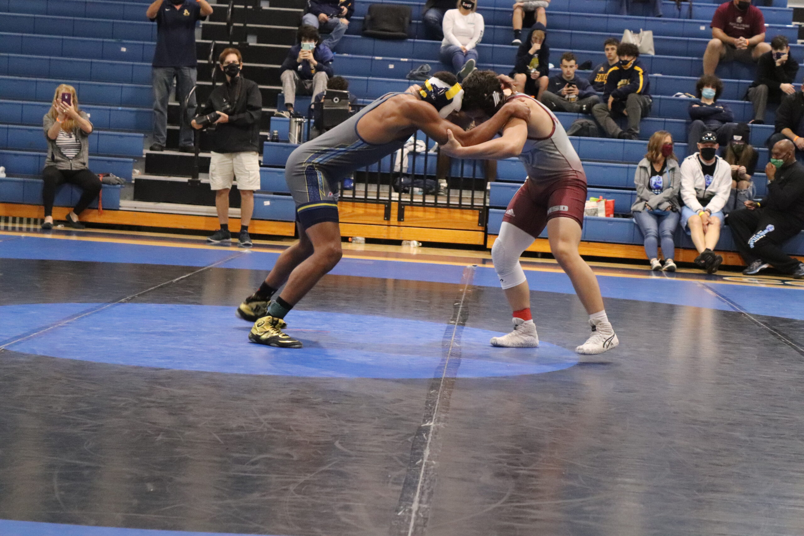 An MSD wrestler faces off an opponent in the BCAA tournament as spectators take pictures and videos. MSD took home a team award for the first time in more than a decade. Photo by Fenthon Aristhomene.