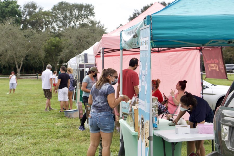 Patrons browse various local booths at the City of Parkland Farmer’s Market. The market reopened on Dec. 6, 2020 after months of COVID-19 restrictions kept it closed. Photo by Bryan Nguyen