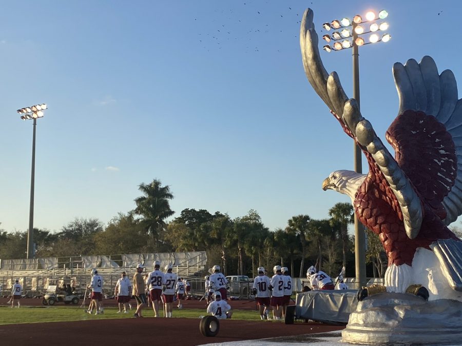 The MSD mens varsity lacrosse team reenters the field after their halftime huddle in their game against Coral Springs High School. The team is pictured next to the Eagle statue found at the front side of the field.