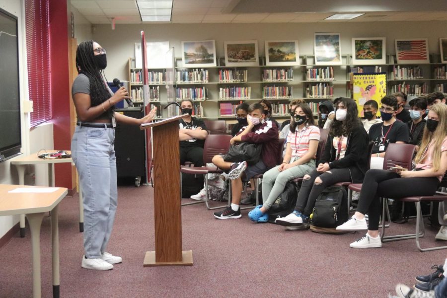 Tapping into character, junior Noldine Belizaire emotionally acts out a monologue in the media center from the book "With Their Eyes" on Friday, Sep. 10, as a part of the Drama Club's presentation. In remembrance of the 9/11 attacks, "With Their Eyes" contains 23 perspectives of students and faculty at Stuyvesant High School that witnessed the attacks on the World Trade Center.