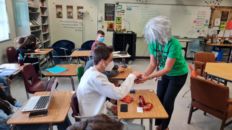 Assistant Principals David Lecthman and Kristine Knap hand out candy to students in the 200 building classrooms during second period on Oct. 28 before the Halloween weekend.