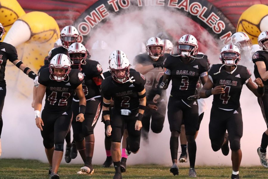 The Eagles run out of the tunnel all hyped up to start the Pig Bowl against Coral Springs High.