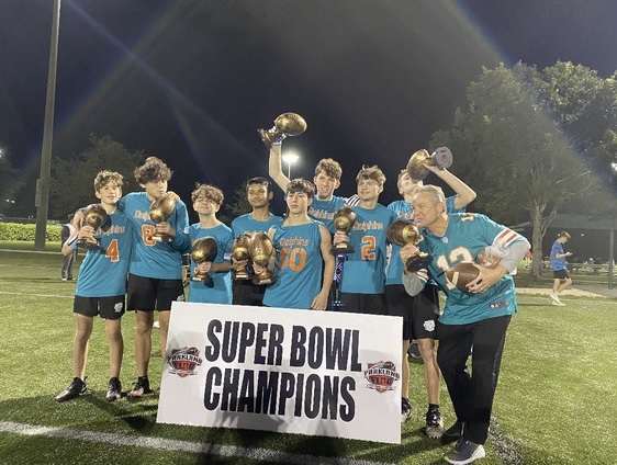 The Parkland Dolphins celebrate with their trophies after achieving a victory in the Parkland Flag Football League Super Bowl.