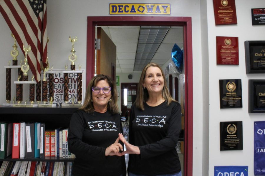 DECA teachers Mrs. Cutler and Mrs. Webster pose eagerly for their picture. The two DECA teachers wore matching shirts in preparation for their photo.