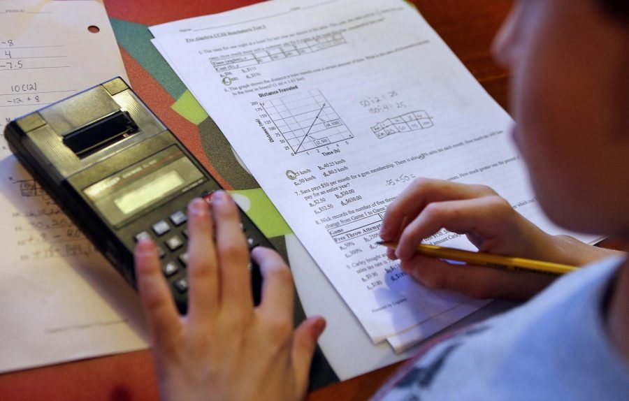 Sixth-grader Kyle Stilwell, 12, works on his pre-algebra study guide as mom Niki works from home on December 12, 2013, in Fenton, Mo. Photo courtesy of Stephanie S. Cordle/St. Louis Post-Dispatch/TNS.