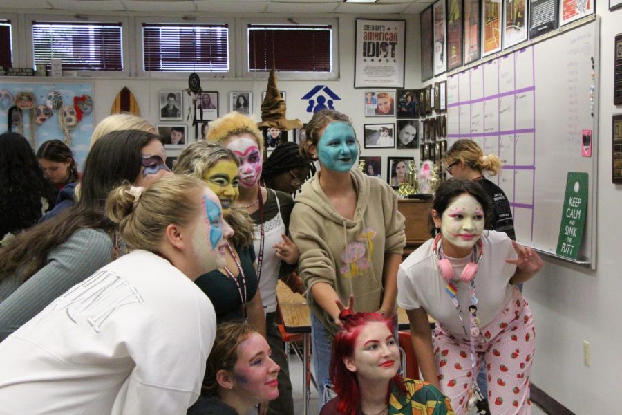 Smile. Students in Mrs. Hertzfelds new costumes, makeup, and hair class pose for a picture with all their completed makeup looks. Students took a wide range of approaches to their looks, using differnt colors and styles.
