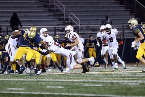 Saint Thomas Aquinas running back (14) is about to score a touchdown. MSD player Marshall Jaillet (56) attempts to tackle him.