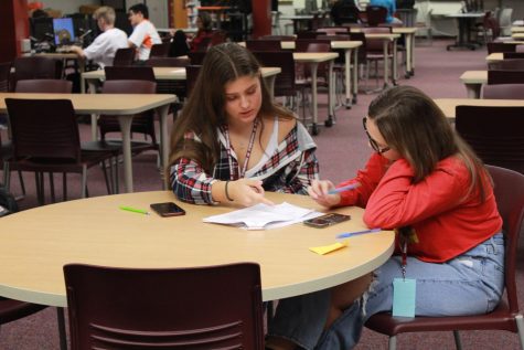 Two girls work together for a genius bar tutoring. Students can go during their study hall and be matched with a tutor for the year to help in any core class.