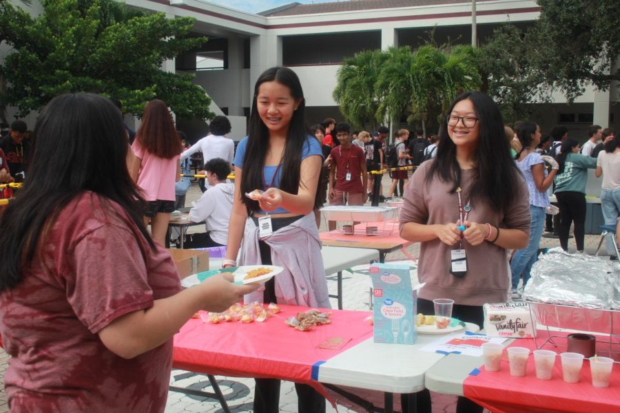 Fortune cookie fun. Students in the Asian Student Association pass out different asian foods to teachers and students going through the line. One item they are passing out are fortune cookies.