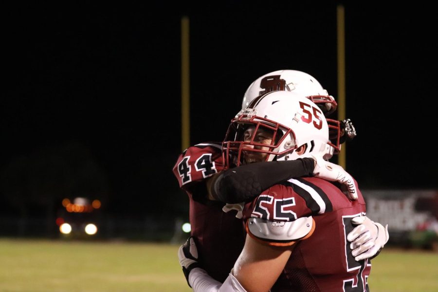 Huggin’ it Out. Defensive lineman Justin Valentine (55) and linebacker Zachary Kracjczewski (44) celebrate the MSD varsity football team’s victory against McArthur High School in their first game of the season on Aug. 26. The Eagles ended the game 29-20.