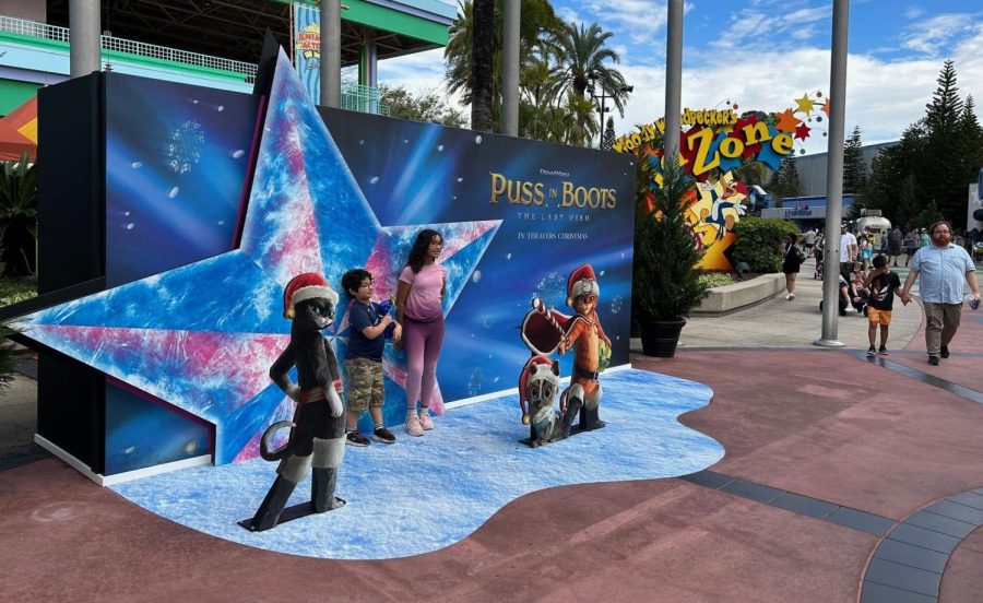 Universal Orlando visitors pose in front of a promotional backdrop for Puss in Boots: The Last Wish. Photo courtesy of 	Dewayne Bevil/TNS.