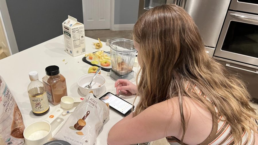 Mixin’ it up. Westglades student Alyssa Landy blends the apple baked oats mixture, while reviewing the recipe online. The short nature of TikTok videos makes them easy to follow and imitate in a short amount of time.