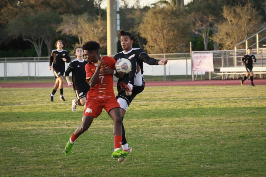 Defender Mauricio Jimenez (11) tries to take the ball from the other team in a match against South Broward High School. Jimenez is one of the seven seniors on the men's varsity soccer team.