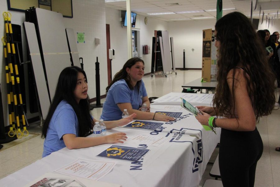 Its an honor. Senior Ivy Lam and junior Abigail Melamed talk to an incoming freshman about National Honor Society. NHS is an academic based honor society that students are invited to join starting their junior year.