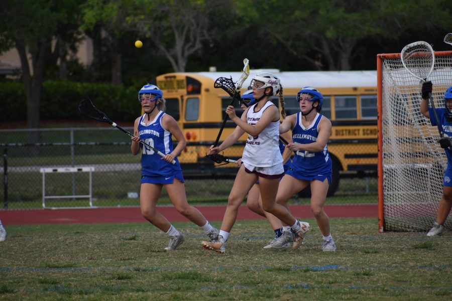 Attacker Stephanie Bilsky (25) passes the ball to fellow teammates to help the Eagles in an attempt to score a goal. Bilsky contributed to her team both on offense as an attacker and defense as a midfielder. The Eagles were able to defeat Wellington High School with a final score of 16-12.