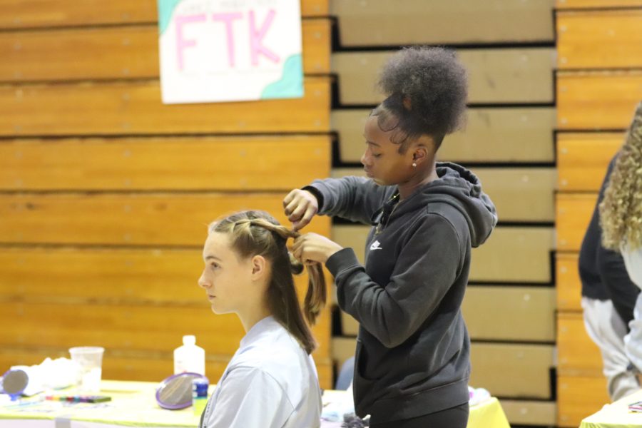 Grace Dykstra gets her hair bubble braided in the Hair Station. The money students used to buy a service like this went into the final tally of money that would be collected and showed at the end of the day to be donated to Nicklaus Childrens Hospital.