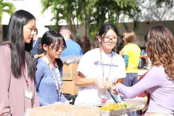 Representing the Asian Student Association, sophomore Ella Li, junior Tam-an Nguyen and senior Karen Liu serve food at the annual ISA Food Fair. There, members of different cultural clubs hand out food that relates to their culture on Oct. 19.