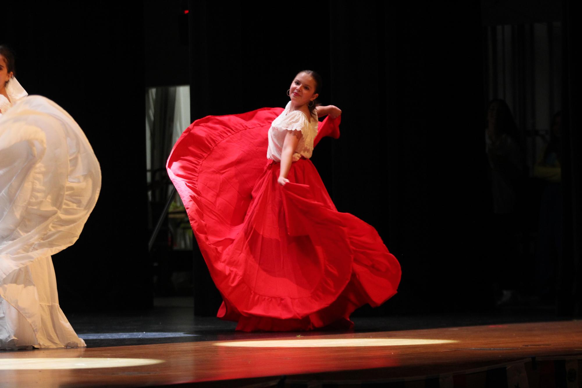 Starting Off. Twirling in her dress, sophomore Valeria Gutierrez dances on stage during zapateado tradicional. This dance originates from Mexico which consists of a flamenco dance with rhythmic stamping of the feet. 