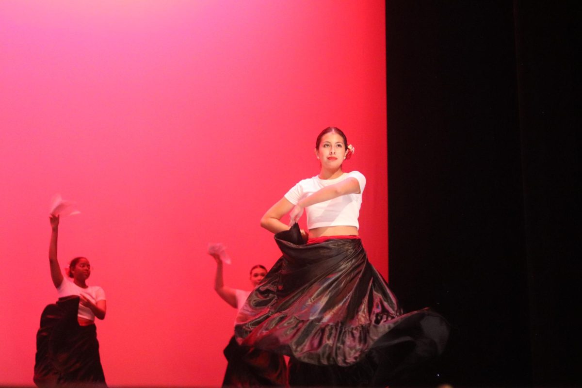 Junior Melanie Anaya twirls her skirt during the Marinera dance of the Multicultural Show. The traditional Peruvian dance was choreographed by junior Isabella Gestro.