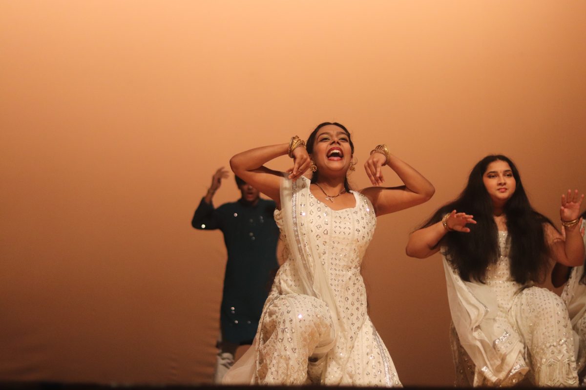 During the Indian Kuthus performance, senior Devika Vikas dances with her hands in the air using light footed and skillful movements. Indian Student Association members organized and danced for the Indian Kuthu and Bollywood dances during the Multicultural Show on Dec. 1.