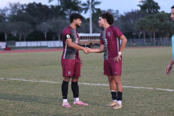 Captain Ian Selveraj (10) and Midfielder Anthony Carnuccio (5) congratulate each other for a good first half against the Cardinal Gibbons Chiefs. The Eagles played the Chiefs on Dec. 5, and finished with a score of 2-1.