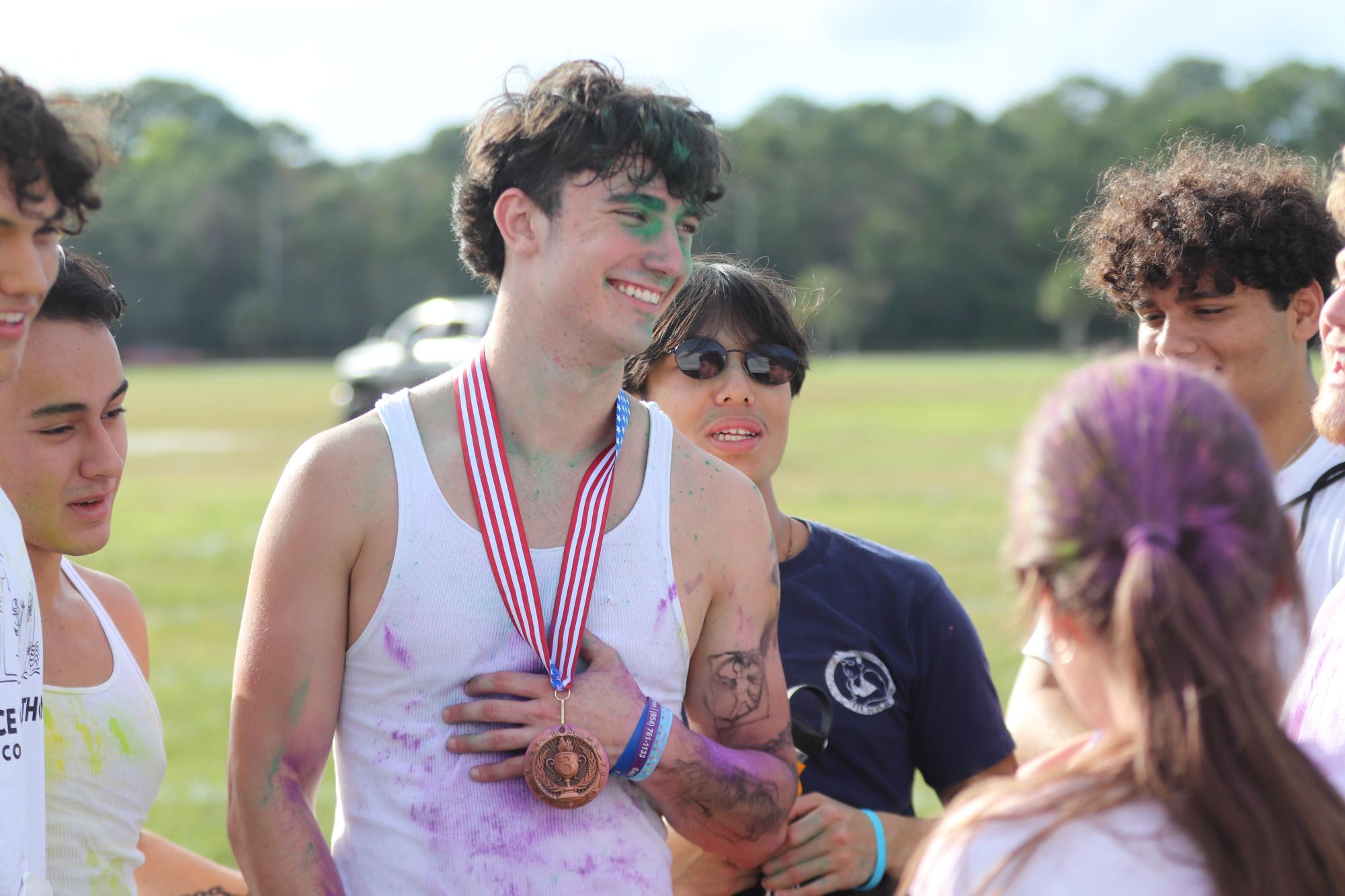 Covered in Color. Surrounded by friends, Senior Seth Goldstein celebrates his third place victory. The color run was hosted by Dance Marathon in hopes to raise money for Children’s Miracle Network. 