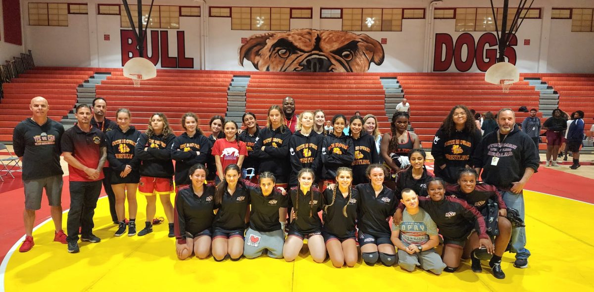 The+MSD+Lady+Eagles+wrestling+team+poses+for+a+picture+after+their+victory+against+South+Broward.+The+Eagles+won+42-36+in+a+historical+match.