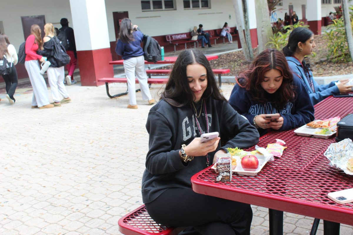 Students+eat+lunch+in+the+courtyard+while+scrolling+on+their+phones.+This+has+become+an+increased+phenomenon+in+recent+years.