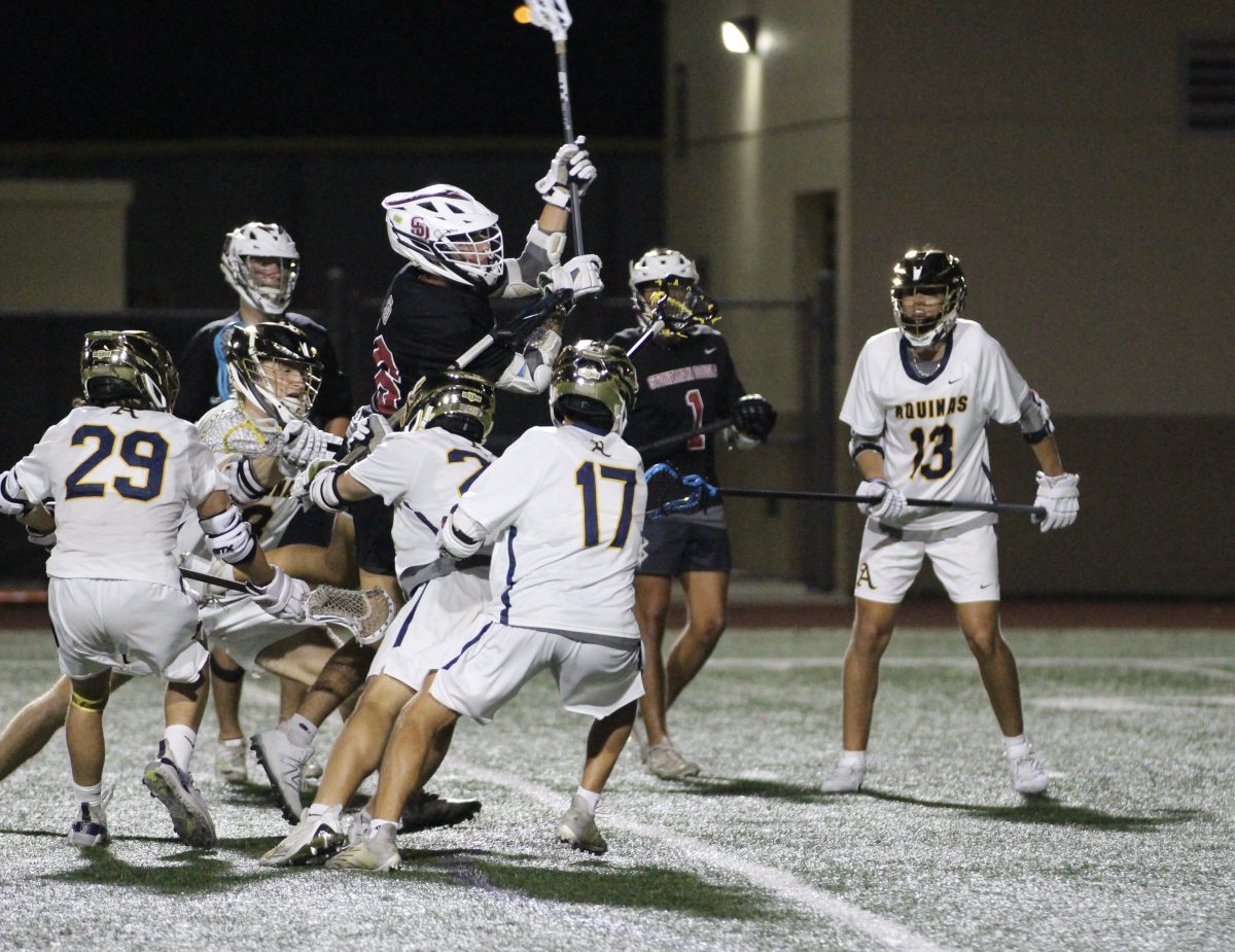 Junior Mikey Fierstat (26) soars through the air over four STA players to shoot for the goal. The Marjory Stoneman Douglas Eagles faced St. Thomas Aquinas in the finals of the 2024 FHSAA Boys Lacrosse District Tournament on April 12.