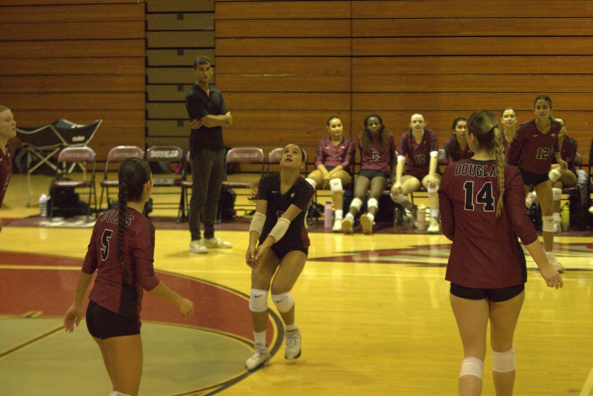 About to hit the ball, defensive specialist of the women's varsity volleyball team Chloe Siqueira (8) puts effort into the play. She scored many points for the Eagles in their game against Cooper City High School on Sept. 25 in MSD's gymnasium.