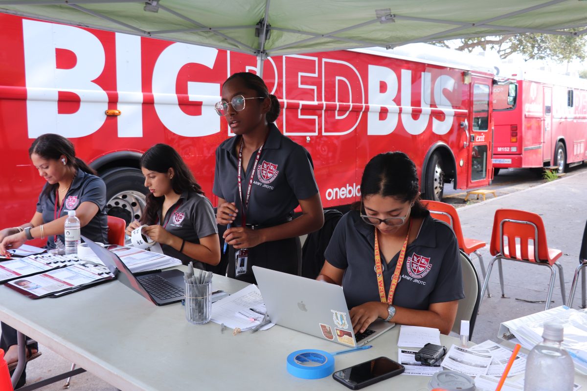 Junior Zoe Brooks answers students' questions on where to go after signing them into the JROTC blood drive on Oct. 2. The students proceeded to get their vitals checked and went through all other necessary steps, including physicals, so that they could donate blood.