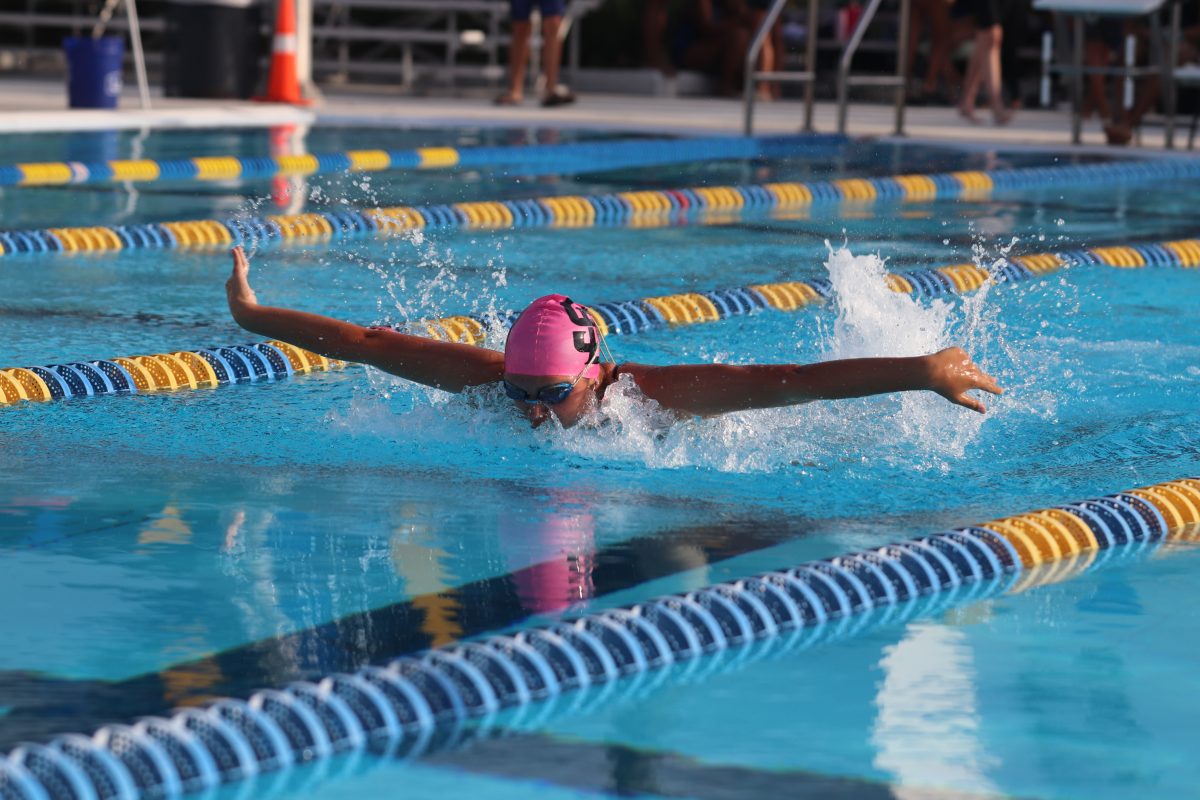 Coming up for a breath, senior Brittany Bean extends her arms while swimming against J.P. Taravella in the girl's 100-yard fly on Tuesday, Oct. 15 at the Coral Springs Aquatic Center. Bean finished second in this event with a time of 1:12, as well as competed in three other events. "I feel I did very well at the meet, but I would like to improve in my 500 and 100-yard fly because those are the events I am competing in for districts," Bean said.