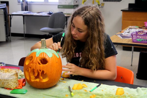 Junior Sophia El Chantiry carves her Snow White-inspired pumpkin. In AP Environmental Science teacher Tammy Orilio's class, she had students bring in pumpkins to carve.