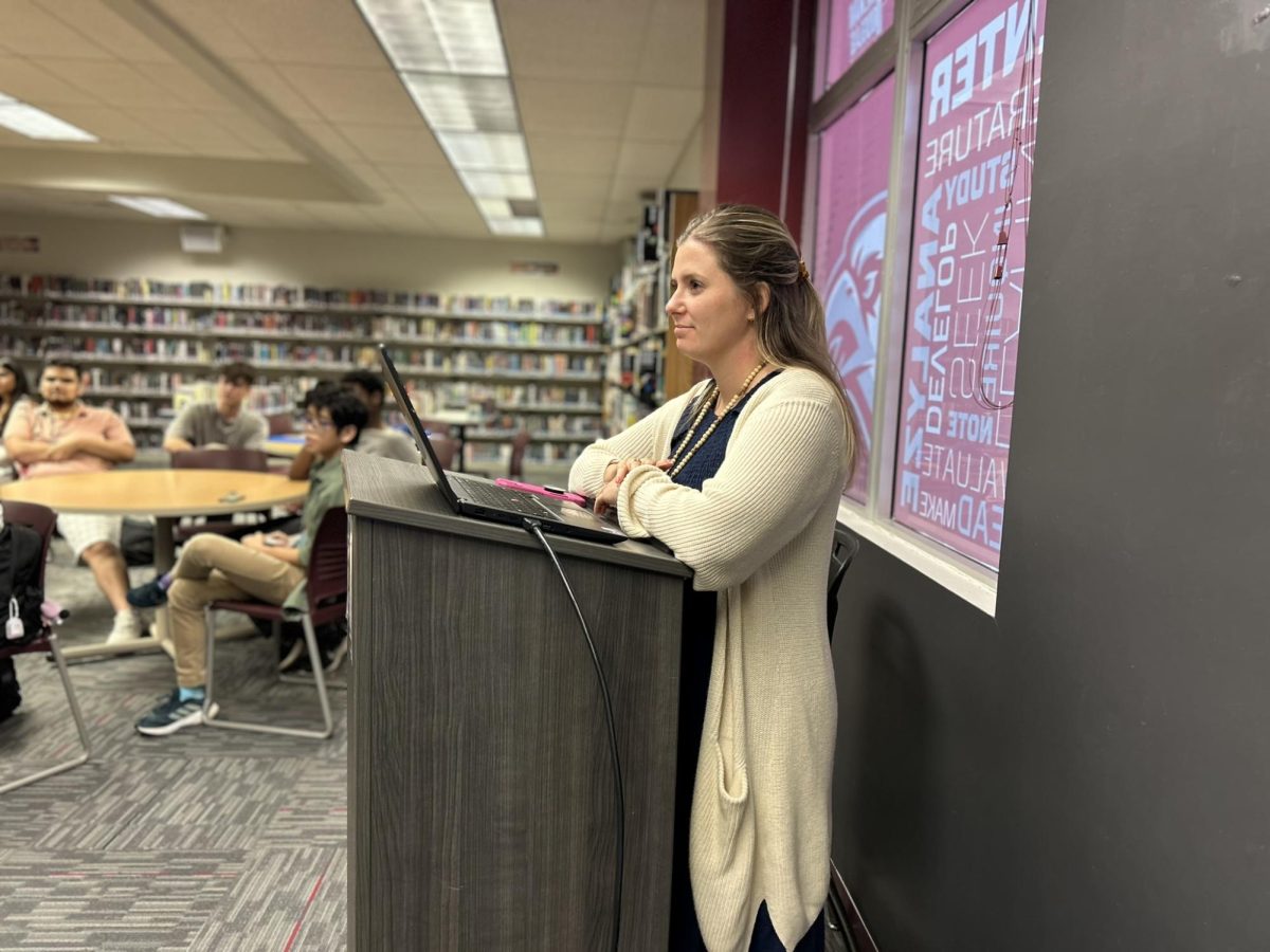 National Honor Society Sponsor Lauren Saccomanno watches guest speaker Albert Price speak to NHS members. National Honor Society held their monthly meeting with Price on Monday, Nov. 4. "[Volunteering] varies on the years and the month, but we have started a couple new things; one of our officers Grace started a soccer program," Saccomanno said. "We have been able to continue older programs, too, like tutoring at Riverglades. NHS's goal is to have as many service projects as possible."