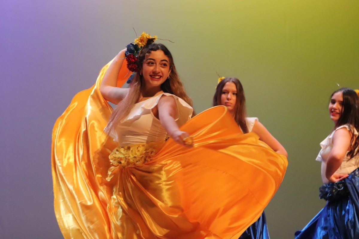 Senior Mariana Rojas Ramos dances through the cumbia routine. Rojas also danced in the Mexican Folklore and jive performances.