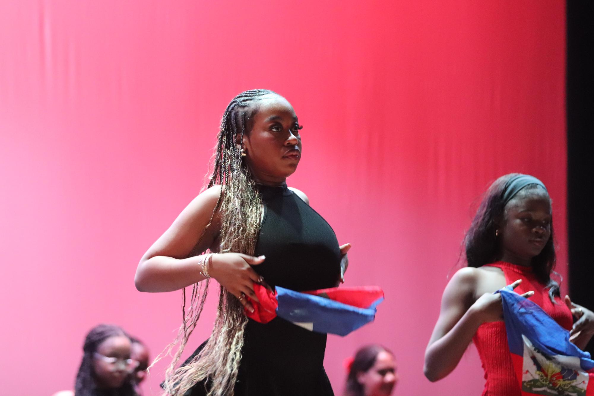 Senior Thatiyana Drouillard dances with the Haitian flag during the Haitian dance in the Multicultural Show. The Multicultural Show took place on Friday, Dec. 6.